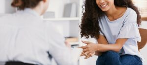 A mother smiles while sitting across from a woman with a clipboard. This could symbolize the support that child counseling in Boulder, CO can offer for parents and their kids. Learn more about the help an anxiety therapist in Boulder, CO can offer by searching for online therapy in Boulder, CO today.
