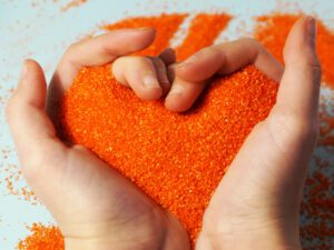 A close up of hands holding sand as it runs through their fingers. Learn more about the support a play therapist for children in Boulder, CO can offer by searching for play therapy in Boulder, CO today. 