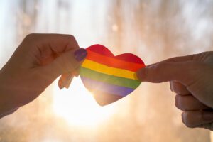 A close up of hands holding a rainbow heart against the light of the sun. This could represent the stronger bonds cultiavted after working with Boulder therapists. Learn more about LGBTQ therapy in Boulder, CO by contacting an LGBTQ therapist in Boulder, CO today. 