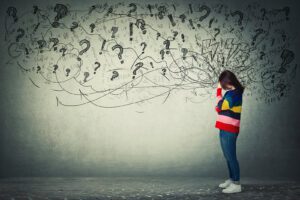 A woman covers her face while exclamation points and question marks hover above and around her. This could represent the stress of anxiety that an anxiety therapist in Boulder, CO can address. Learn more about anxiety in Boulder, CO and tips to address stress symptoms today. Search for anxiety therapist Boulder today to learn more.