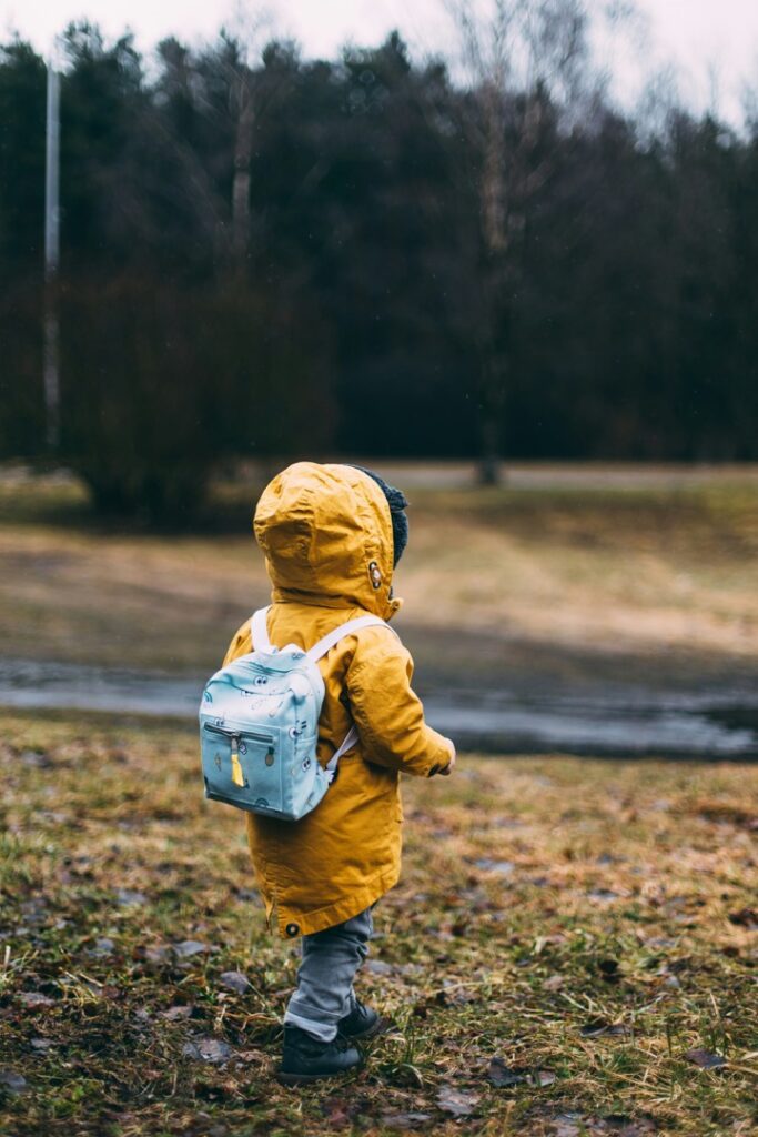 A toddler in a rain jacket and backpack walks on damp grass. This could represent the inner child of a student. Learn more about how a depression therapist in Boulder, CO can help address mental health concerns. Search for anxiety in Boulder, CO to learn more about how an anxiety therapist can help.