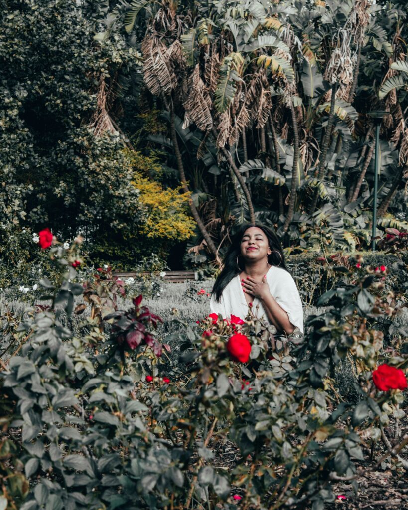 A woman smiles with her eyes closed while standing amid dense foliage. This could symbolize feeling connected with your surroundings after ketamine therapy in Boulder, CO. Contact a ketamine assisted therapist in Boulder, CO to learn more about treatment resistant depression today.
