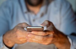 A close up of a man typing on a phone. This could represent how AI can offer support in daily life including online therapy in Colorado. Learn more about the best therapists in Boulder and how mindfulness-based therapy in Boulder, CO can offer support today.